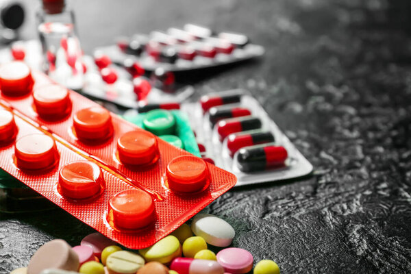 Different pills on dark background