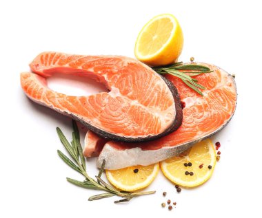 Beyaz arka planda çiğ somon bifteği ve limon