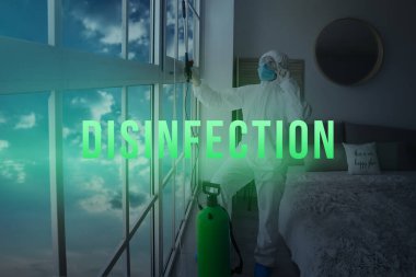 Biyolojik tehlike giysisi giyen bir işçi evi dezenfekte ediyor.