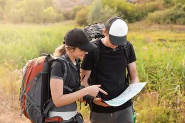 Kırsal kesimde haritası olan birkaç genç turist.