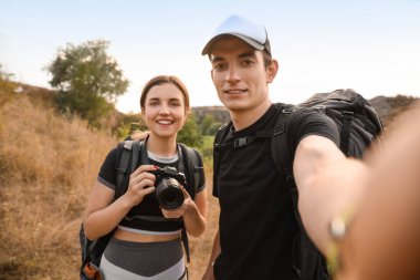 Kırsalda selfie çeken iki genç turist.