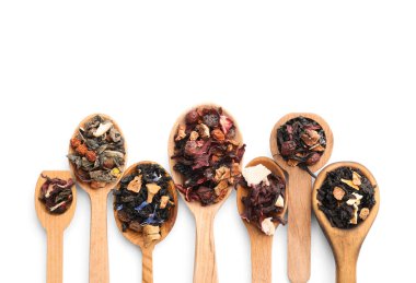Beyaz arka planda farklı türde kuru meyve çayı olan kaşıklar.