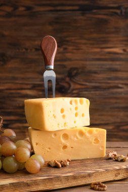 Ahşap zemin üzerinde lezzetli peynir ve üzüm parçaları olan kompozisyon
