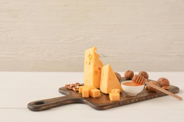 Hafif arkaplanda lezzetli peynir ve ceviz parçaları.