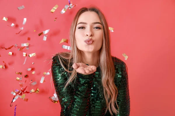 Feliz Joven Mujer Soplando Beso Caída Confeti Fondo Color — Foto de Stock