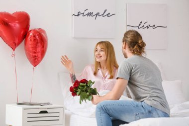 Genç adam sevgililer gününde sevgilisini evde karşılıyor.