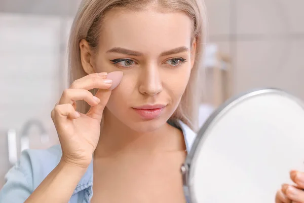 Vacker Ung Kvinna Med Svamp Tillämpa Makeup Hemma — Stockfoto