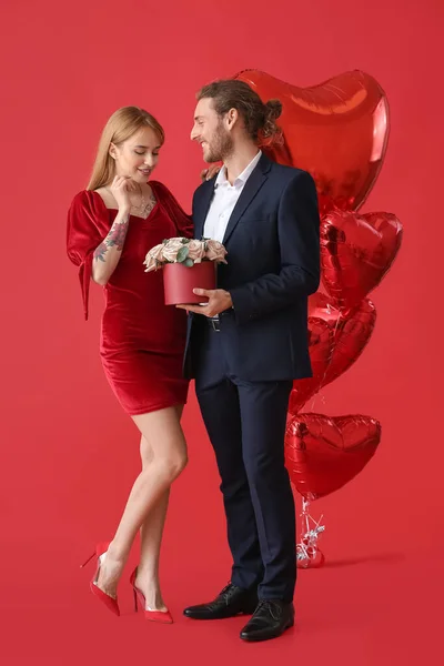 Junges Paar Mit Blumen Und Luftballons Auf Farbigem Hintergrund Valentinstag — Stockfoto
