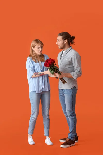 Junger Mann Grüßt Seine Unzufriedene Freundin Valentinstag Vor Farbigem Hintergrund — Stockfoto