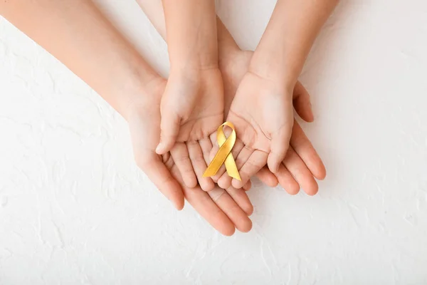 Mãos Com Fita Dourada Sobre Fundo Branco Conceito Conscientização Câncer — Fotografia de Stock