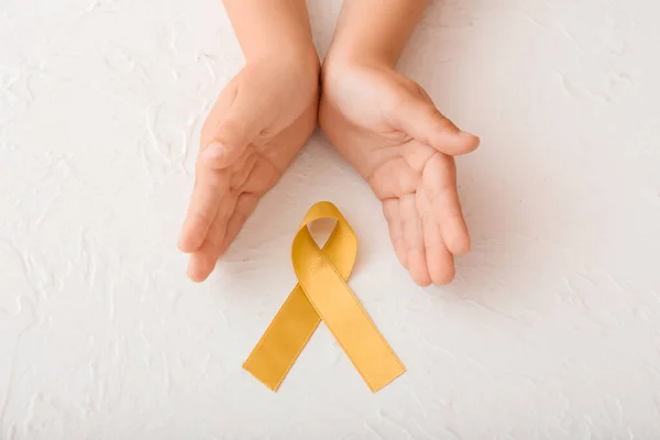 Mãos Com Fita Dourada Sobre Fundo Branco Conceito Conscientização Câncer — Fotografia de Stock