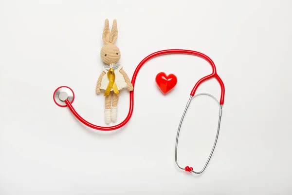 Altın Kurdele Steteskop Beyaz Arka Planda Kalp Oyuncak Çocukluk Kanseri — Stok fotoğraf