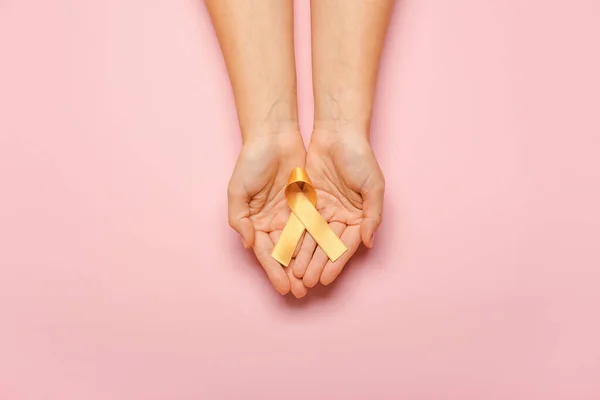 Hands Golden Ribbon Color Background Childhood Cancer Awareness Concept — Stock Photo, Image