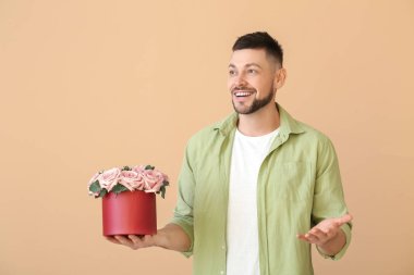 Renkli arka planda bir buket güzel çiçekli yakışıklı adam.