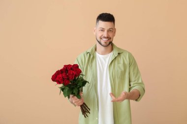 Renkli arka planda bir buket güzel çiçekli yakışıklı adam.