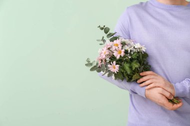 Renkli arka planda bir buket güzel çiçekli yakışıklı adam.