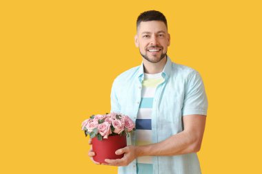 Renkli arka planda bir buket güzel çiçekli yakışıklı adam.