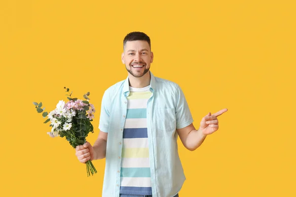 Bonito Homem Com Buquê Flores Bonitas Apontando Para Algo Fundo — Fotografia de Stock