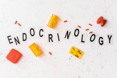 Kelime ENDOCRINOLOGY, tiroid bezi ve beyaz arka planda haplar