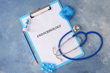 Kelime EnDOCRINOLOGY, steteskop ve renk arkaplan üzerinde haplar içeren pano