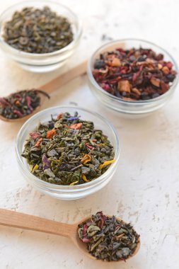 Tabaklar ve kaşıklar ve farklı kuru çay yaprakları.