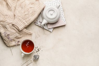 Çaydanlıklı kompozisyon ve arka planda bir fincan çay.