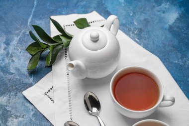 Çaydanlıklı kompozisyon ve renkli arka planda bir fincan çay