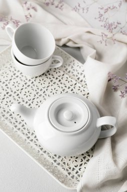 Hafif arkaplanda çaydanlık ve kupalar