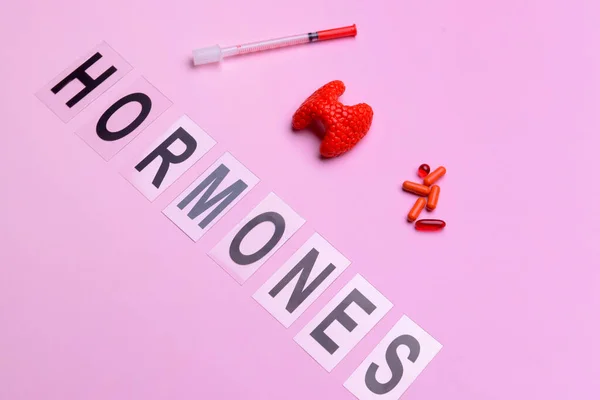 stock image Word HORMONES, thyroid gland, pills and syringe on color background