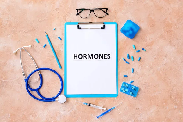 Renk Arkaplanında Hormones Steteskop Şırınga Haplar Yazan Pano — Stok fotoğraf