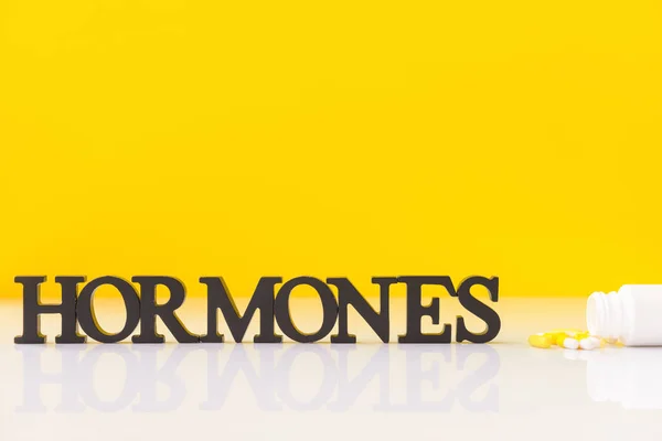 Word Hormones Pills Table Color Background — Stock Photo, Image