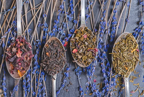Κουτάλια Διαφορετικά Φύλλα Ξηρού Τσαγιού Και Λουλούδια Ξύλινο Φόντο — Φωτογραφία Αρχείου
