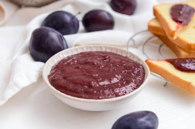 Beyaz arka planda lezzetli ev yapımı erik reçelli kase.