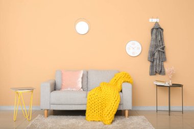 Renkli duvarın yanında ekose örülmüş şık bir kanepe.