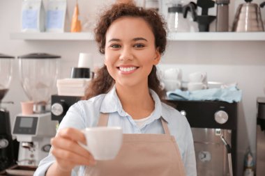 Kafede bir fincan sıcak espresso ile genç barista.