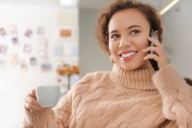 Kafede cep telefonu ve bir fincan sıcak espresso ile güzel bir kadın.