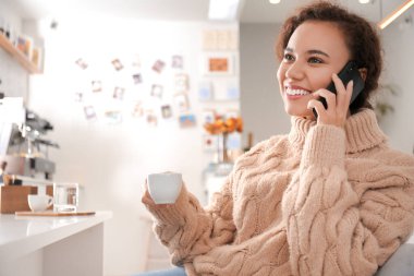 Kafede cep telefonu ve bir fincan sıcak espresso ile güzel bir kadın.