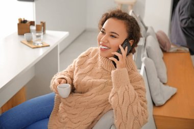 Kafede cep telefonu ve bir fincan sıcak espresso ile güzel bir kadın.