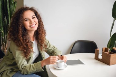 Güzel bir kadın kafede sıcak espresso içiyor.
