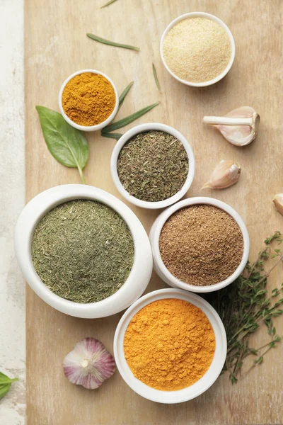 Açık arkaplanda farklı baharat ve bitkiler bulunan tahta