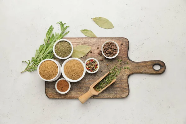 Açık arkaplanda farklı baharat ve bitkiler bulunan tahta