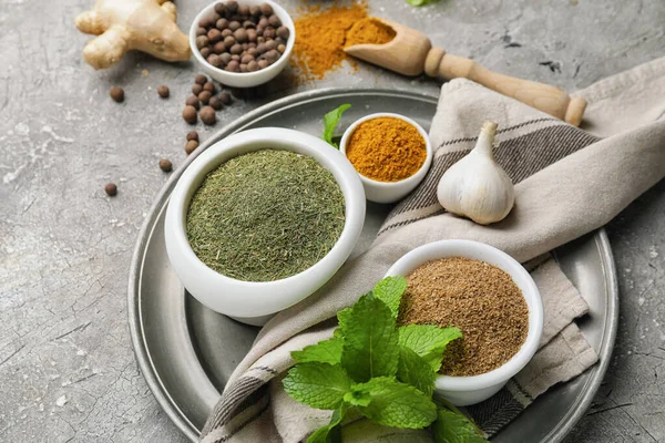 Gri arka planda farklı baharat ve bitkilerle kompozisyon