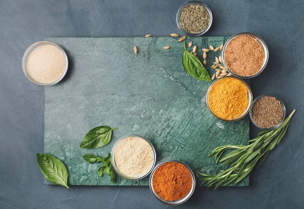 Koyu arkaplanda farklı baharat ve bitkiler bulunan tahta