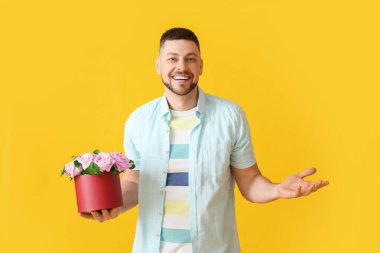 Renkli arka planda bir buket güzel çiçekli yakışıklı adam.