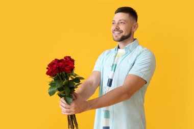 Renkli arka planda bir buket güzel çiçekli yakışıklı adam.