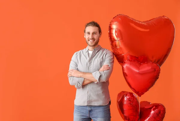 色の背景に気球を持つ若い男 バレンタインデーのお祝い — ストック写真