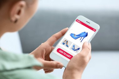 Evde yeni ayakkabılar alan genç bir kadın, yakın plan.