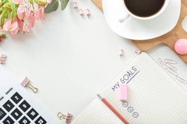 Boş yapılacaklar listesi, takvimi, çiçekleri ve açık arkaplanda bir fincan kahvesi olan defter