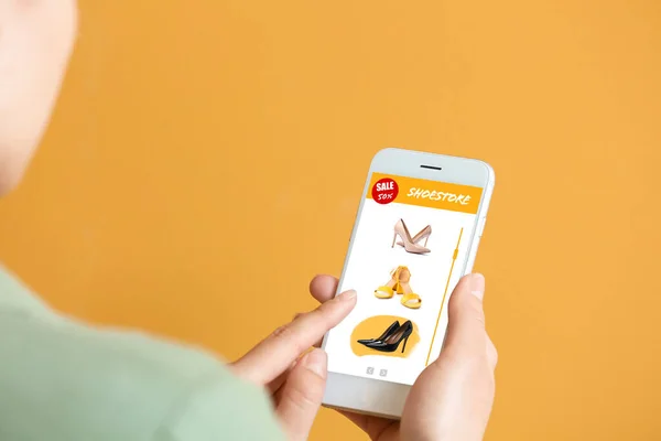 Молода Жінка Тримає Мобільний Телефон Відкритою Сторінкою Інтернет Магазину Взуття — стокове фото
