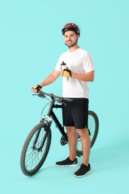 Renkli arka planda su şişesi olan erkek bisikletçi